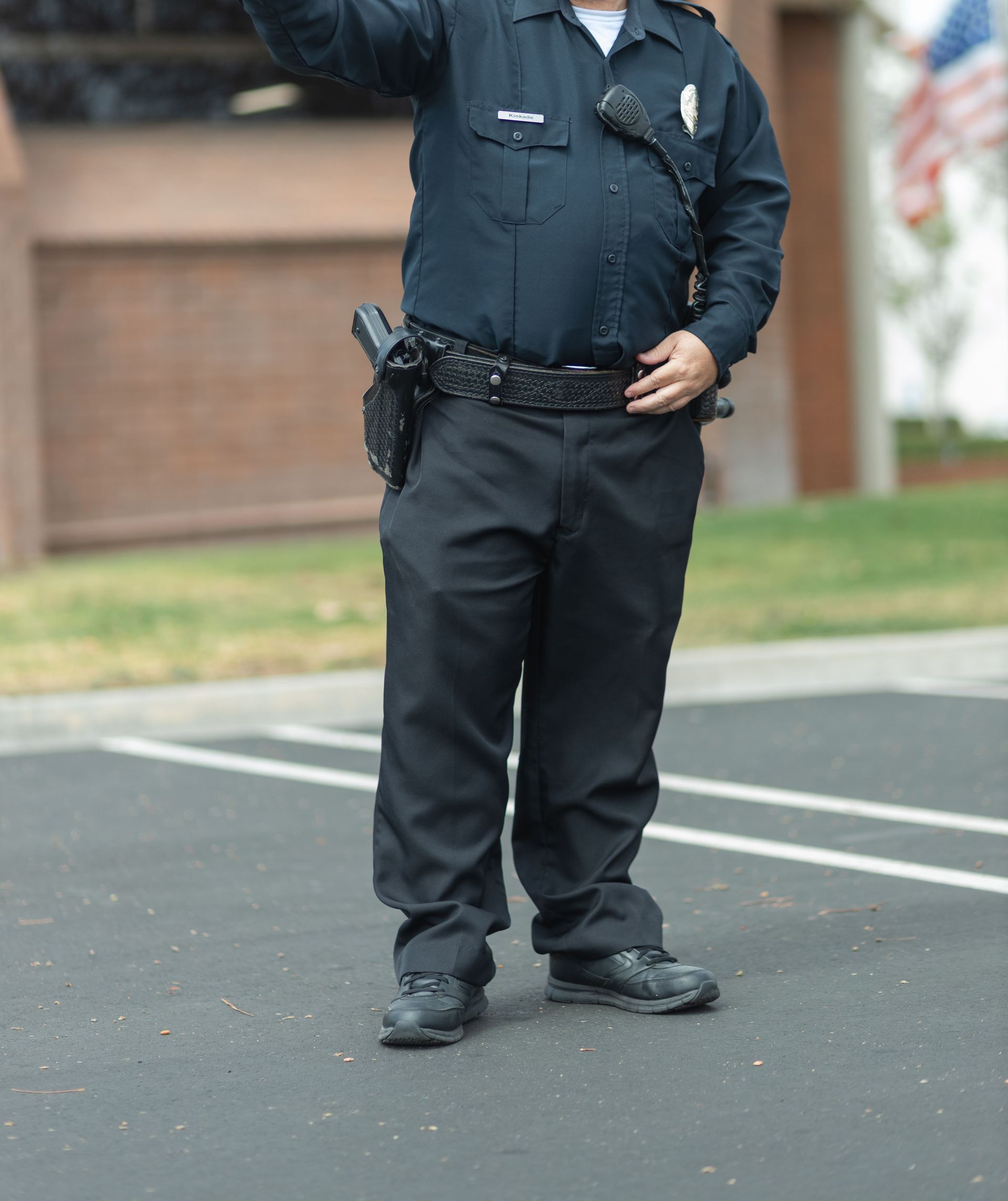 A caucasian police officer in uniform directing traffic outdoors during the daytime.